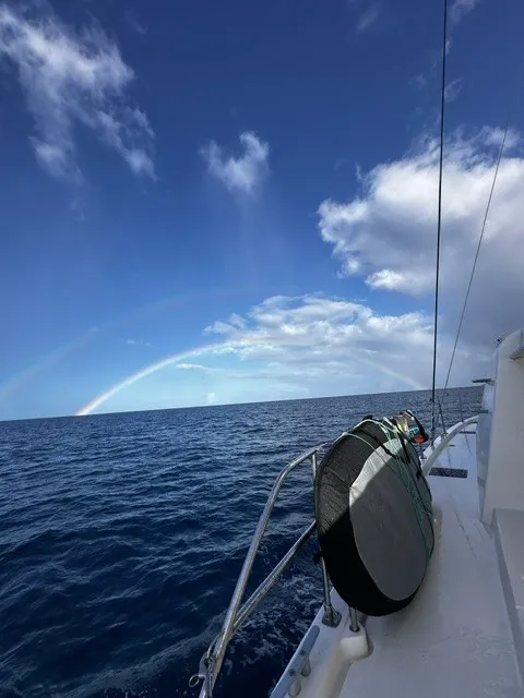 Rainbow over the sea seen from the deck on passage